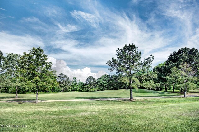 view of home's community with view of golf course and a yard
