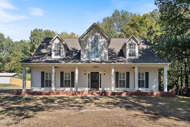 new england style home featuring covered porch and a garage