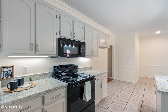 kitchen with white cabinetry, ornamental molding, light tile patterned flooring, black appliances, and light stone counters