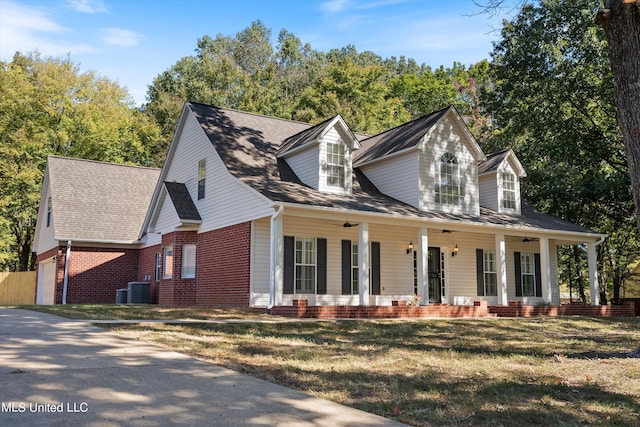 cape cod house featuring a porch, cooling unit, a front lawn, and a garage