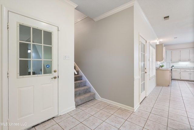 entrance foyer with ornamental molding and light tile patterned flooring