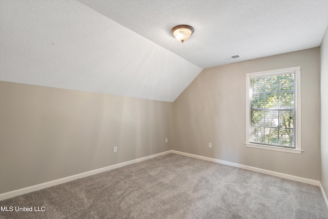 bonus room with lofted ceiling, a textured ceiling, and carpet flooring