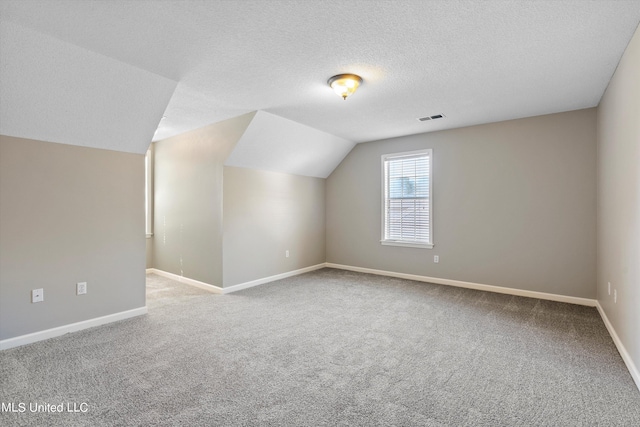 bonus room with lofted ceiling, carpet, and a textured ceiling