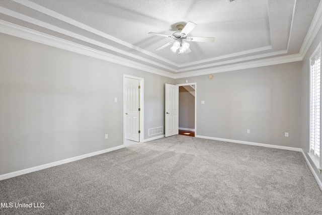 carpeted empty room featuring crown molding, ceiling fan, a textured ceiling, and a raised ceiling