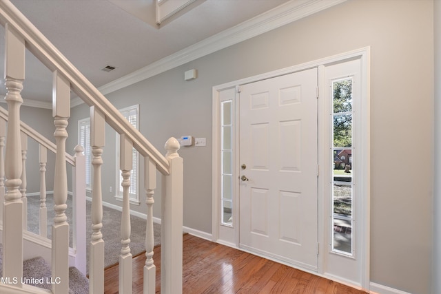 entrance foyer featuring ornamental molding and wood-type flooring