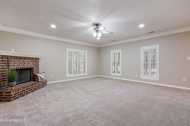 unfurnished living room with a textured ceiling, ornamental molding, a brick fireplace, ceiling fan, and carpet