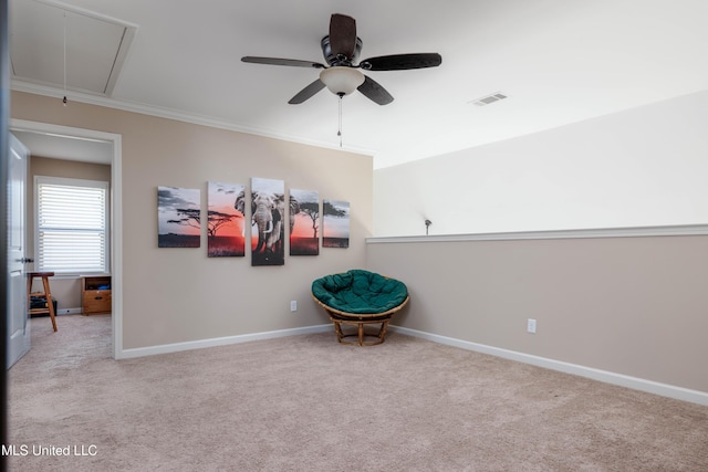 sitting room with ceiling fan, light colored carpet, and ornamental molding