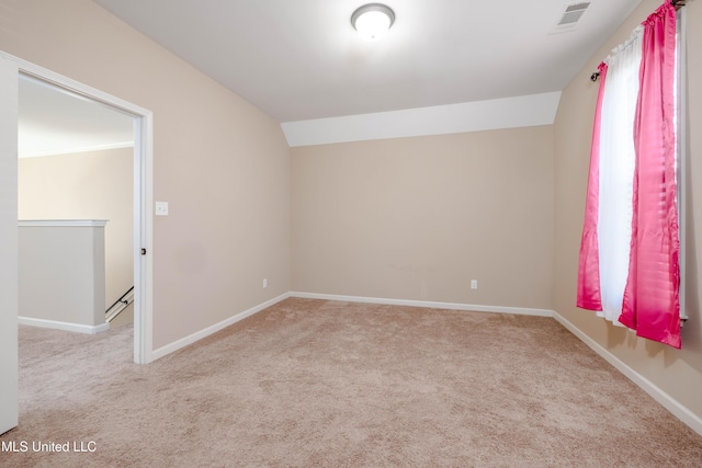 carpeted empty room featuring lofted ceiling