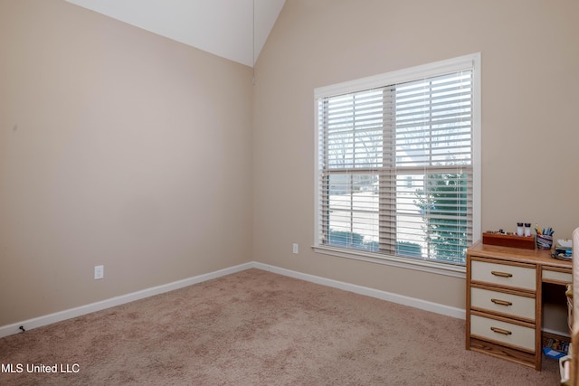 carpeted empty room featuring lofted ceiling