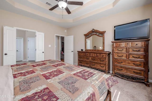 bedroom featuring ceiling fan, carpet flooring, and a raised ceiling