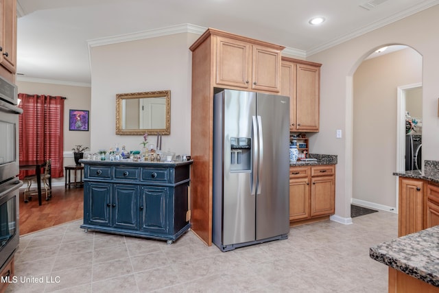 kitchen with stainless steel appliances, crown molding, dark stone countertops, and washer / clothes dryer