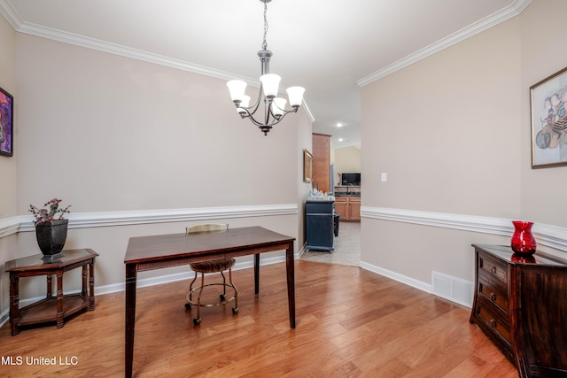 office space featuring light hardwood / wood-style flooring, ornamental molding, and a chandelier