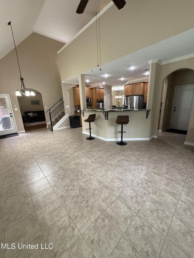 7419 Rose Garden Ln, Olive Branch, MS 38654 - unfurnished living room featuring arched walkways, a ceiling fan, light tile patterned floors, high vaulted ceiling, and crown molding