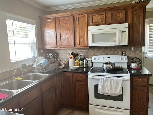 kitchen featuring white appliances, crown molding, decorative backsplash, and sink