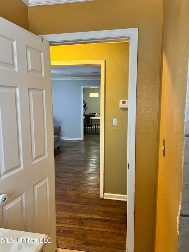 corridor with ornamental molding and dark hardwood / wood-style flooring