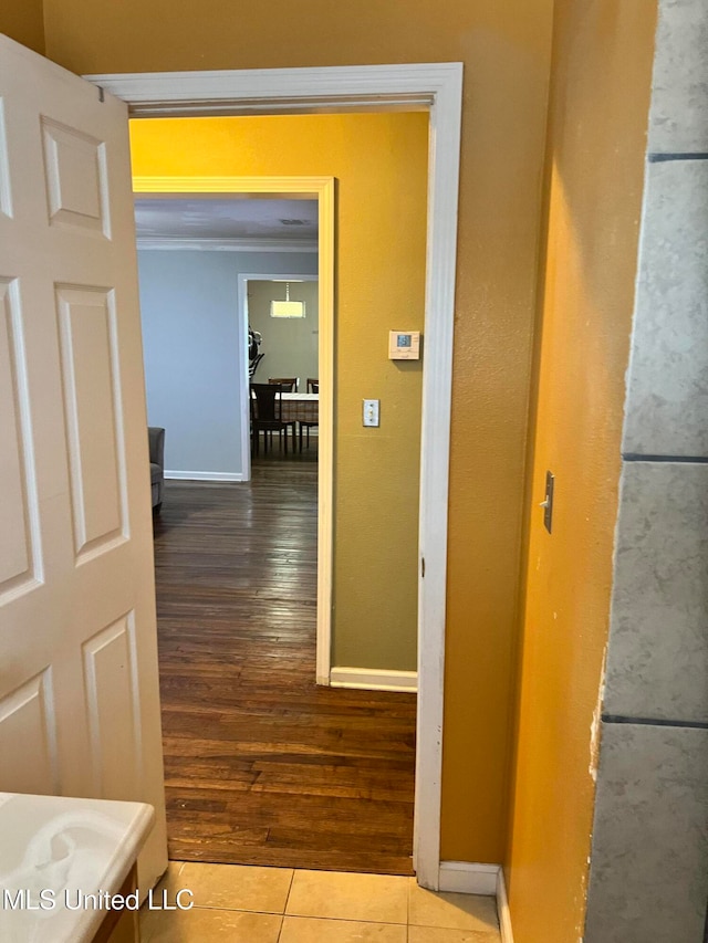 corridor with ornamental molding and hardwood / wood-style floors