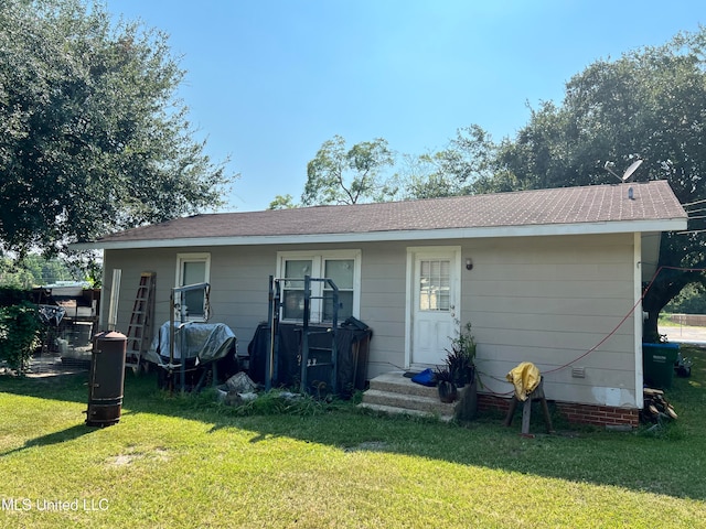 rear view of property featuring a yard