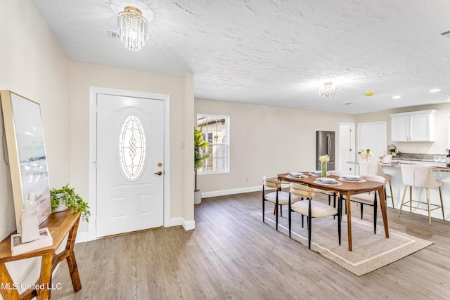 entrance foyer featuring a textured ceiling and light wood-type flooring