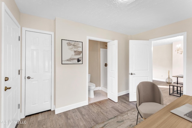 home office featuring a textured ceiling and light wood-type flooring