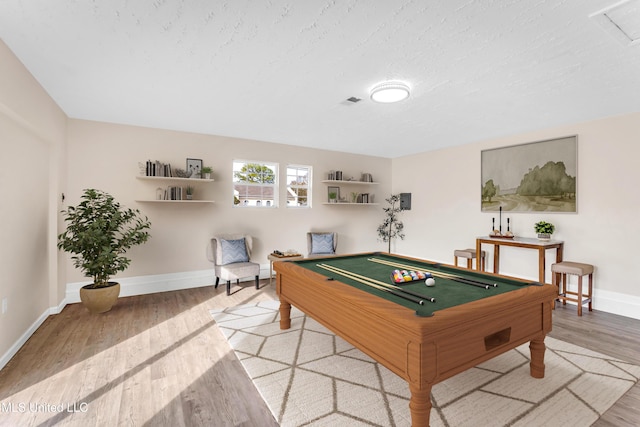 game room with billiards, a textured ceiling, and light wood-type flooring