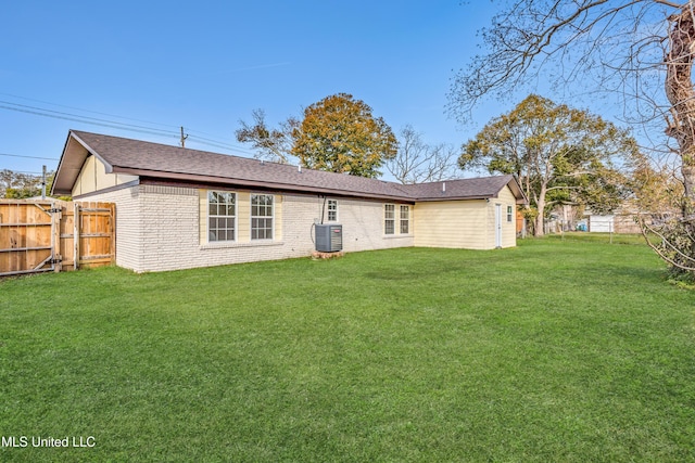 rear view of house with a yard and central air condition unit