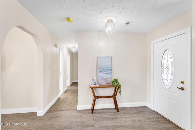 entryway featuring wood-type flooring and a textured ceiling