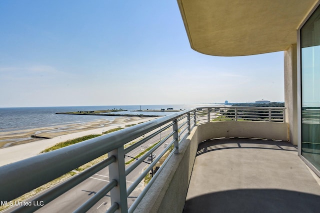 balcony featuring a view of the beach and a water view