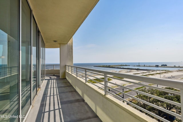 balcony featuring a view of the beach and a water view