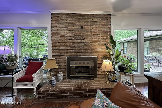 305 Dettor St, Batesville, MS 38606 - living room featuring ornamental molding, wood-type flooring, and a brick fireplace