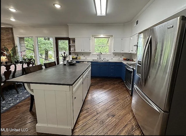305 Dettor St, Batesville, MS 38606 - kitchen featuring stainless steel appliances, blue cabinetry, a sink, dark wood-style floors, and ornamental molding