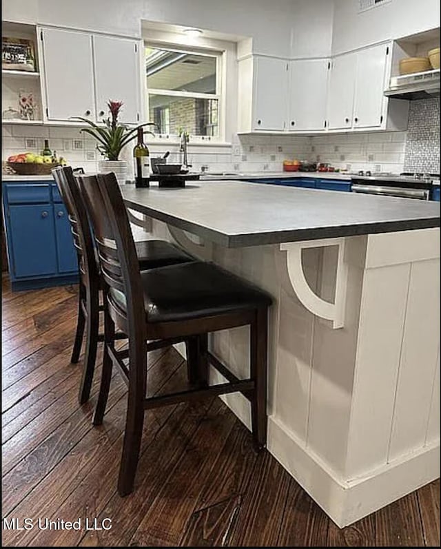 305 Dettor St, Batesville, MS 38606 - kitchen featuring blue cabinetry, open shelves, dark wood-style floors, decorative backsplash, and white cabinetry