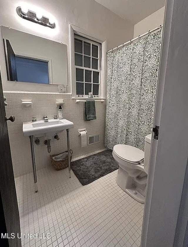 305 Dettor St, Batesville, MS 38606 - full bathroom with toilet, tile patterned flooring, tile walls, a sink, and curtained shower