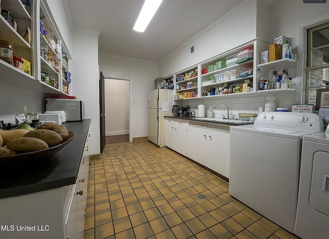 305 Dettor St, Batesville, MS 38606 - kitchen featuring open shelves, freestanding refrigerator, washing machine and clothes dryer, white cabinets, and a sink