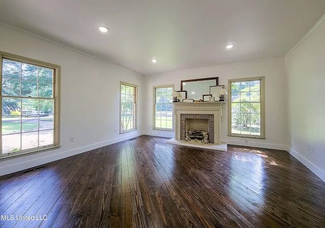 305 Dettor St, Batesville, MS 38606 - unfurnished living room with crown molding, baseboards, dark wood-style flooring, a brick fireplace, and recessed lighting
