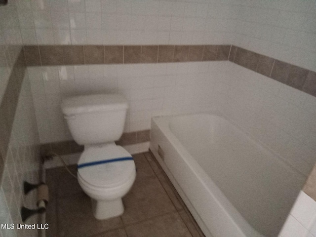 9219 Anding Oil City Rd, Bentonia, MS 39040 - bathroom with tile patterned flooring, toilet, tile walls, and a tub to relax in