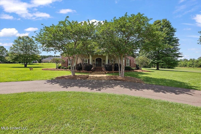 view of property hidden behind natural elements with a front yard