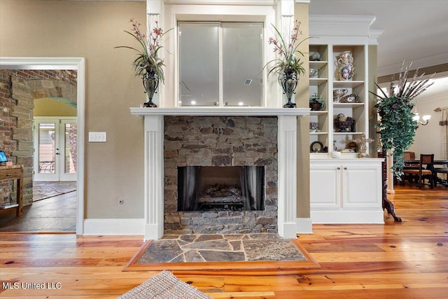 living room with a stone fireplace and hardwood / wood-style flooring