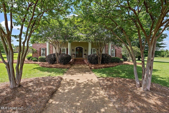 obstructed view of property featuring covered porch and a front yard