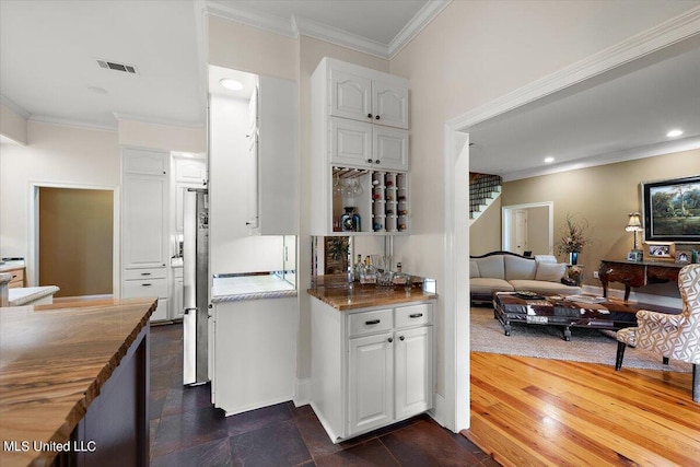 kitchen with stainless steel refrigerator, white cabinets, butcher block counters, and dark hardwood / wood-style flooring