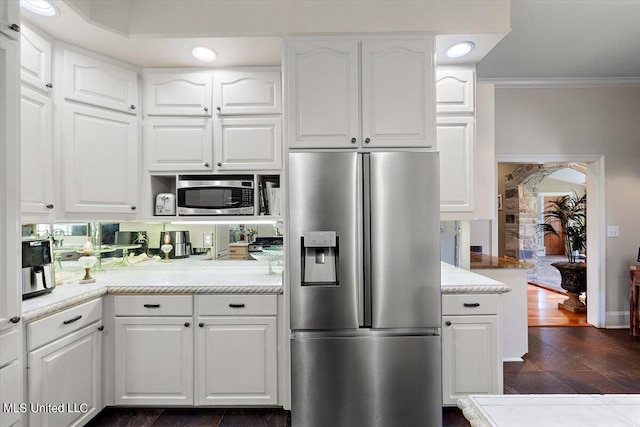 kitchen featuring crown molding, appliances with stainless steel finishes, dark hardwood / wood-style floors, and white cabinets