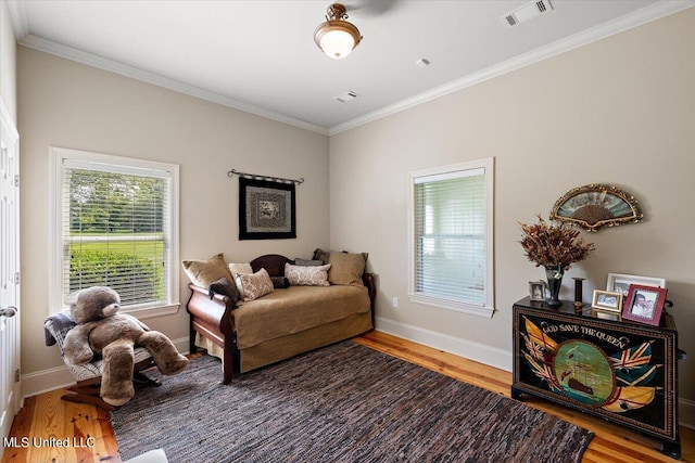 living area with hardwood / wood-style flooring and ornamental molding