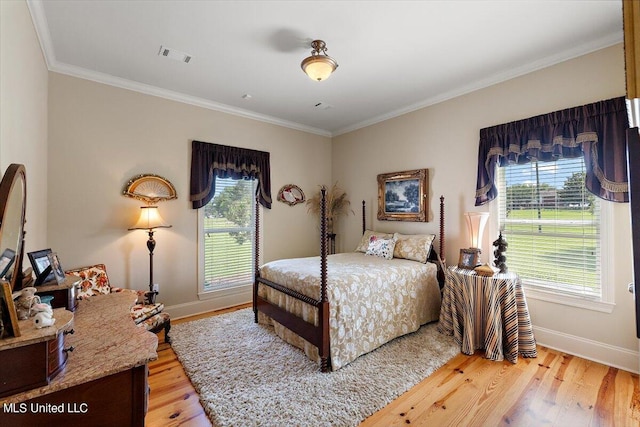 bedroom with light hardwood / wood-style floors and ornamental molding