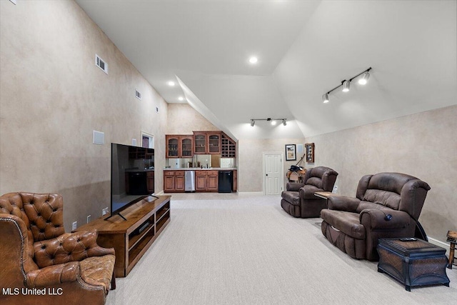 living room with lofted ceiling, light colored carpet, and rail lighting