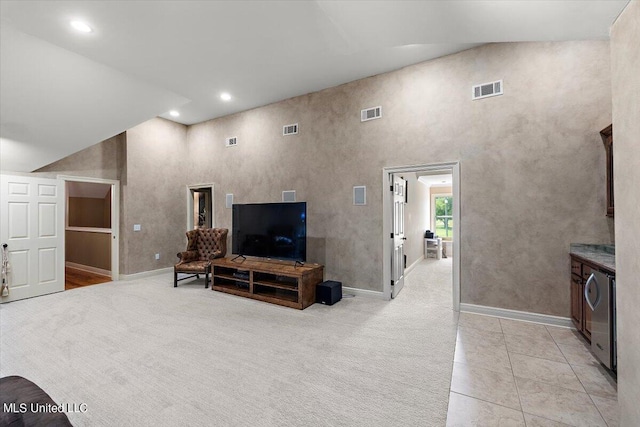 carpeted living room with a towering ceiling