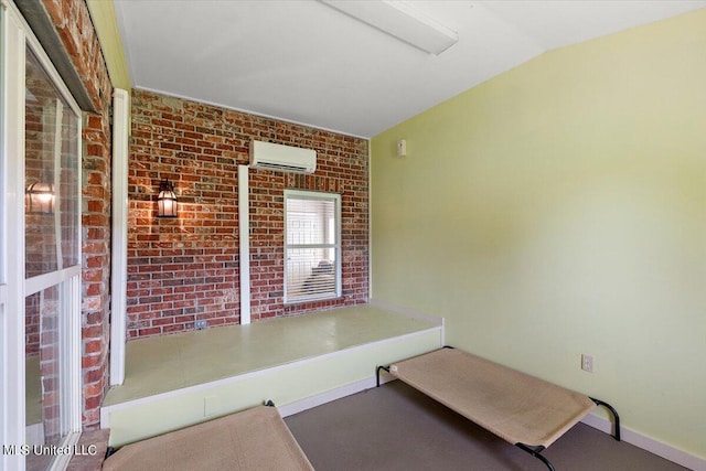 interior space with an AC wall unit, vaulted ceiling, and brick wall