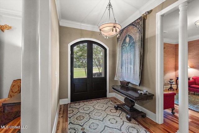 foyer entrance with light hardwood / wood-style flooring, ornate columns, and crown molding