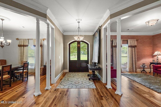 entrance foyer featuring crown molding, a notable chandelier, hardwood / wood-style flooring, and a healthy amount of sunlight