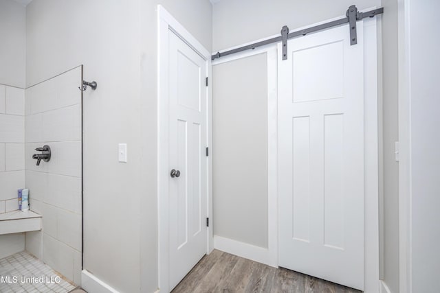 bathroom featuring hardwood / wood-style flooring and tiled shower