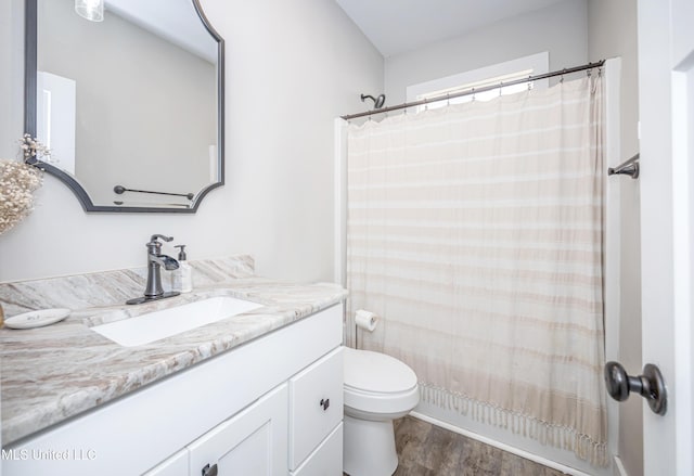 bathroom with vanity, curtained shower, wood-type flooring, and toilet