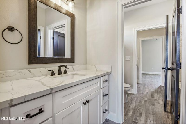 620 Old Savannah Dr, Long Beach, MS 39560 - bathroom featuring vanity, toilet, wood finished floors, and baseboards